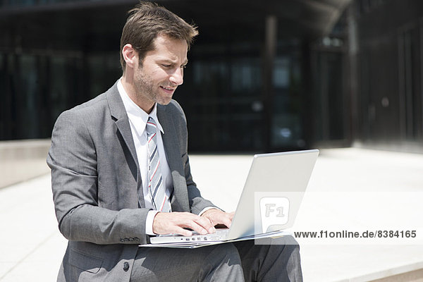 Businessman using laptop outdoors