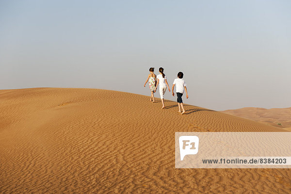Children walking in desert  rear view