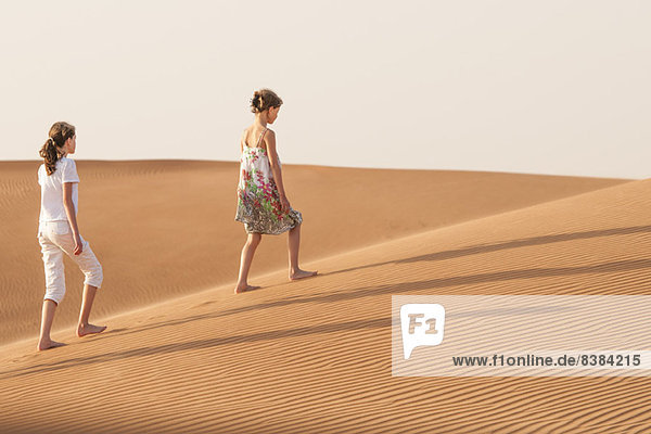 Mädchen  die in der Wüste spazieren gehen