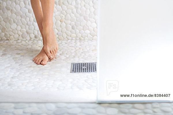 Frau in der Dusche stehend  abgeschnittene Ansicht der Füße