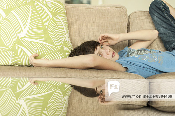 Teenager-Junge auf dem Sofa liegend