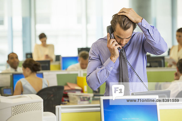 Businessman talking on telephone in office