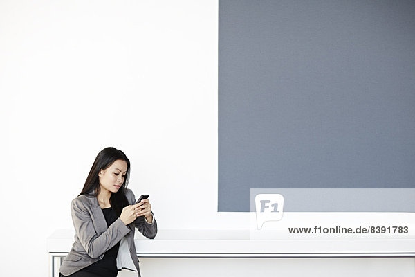 Businesswoman using cell phone in office