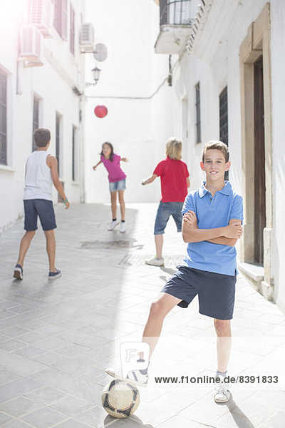 Boy holding soccer ball in alley
