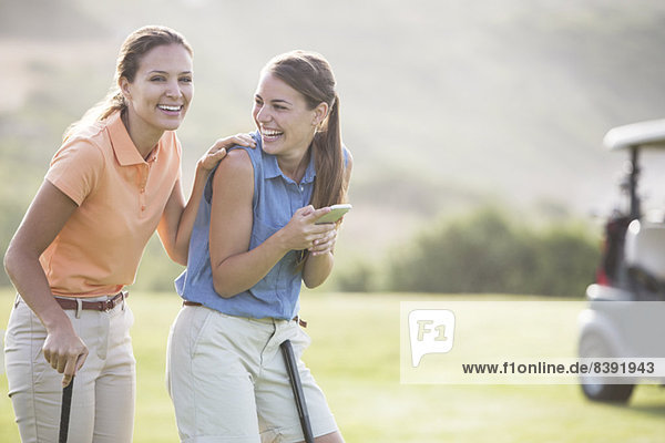 Frauen lachen auf dem Golfplatz
