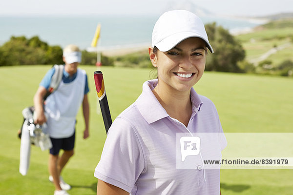 Lächelnde Frau auf dem Golfplatz