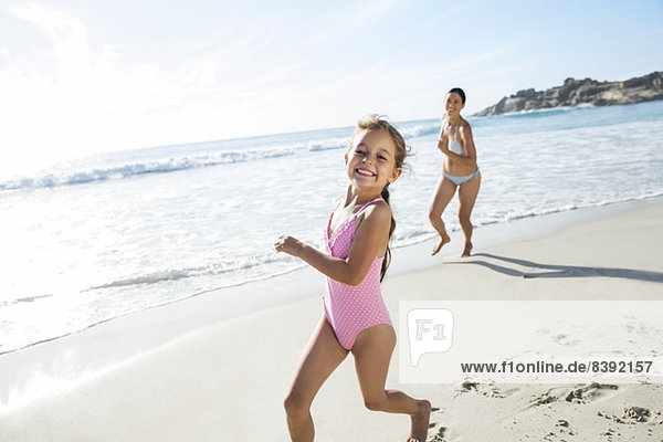 Mutter und Tochter beim Laufen am Strand