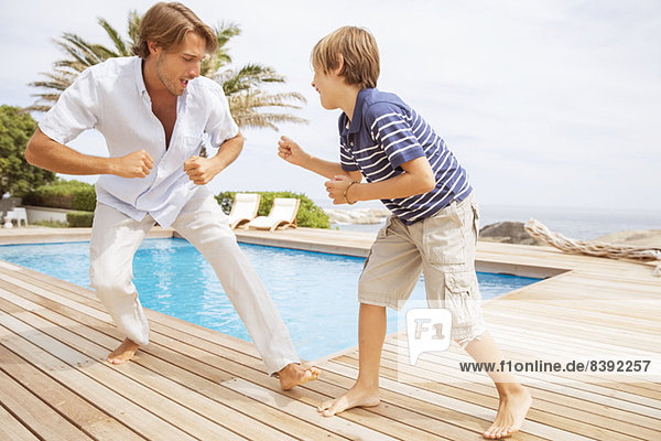 Vater und Sohn spielen am Pool