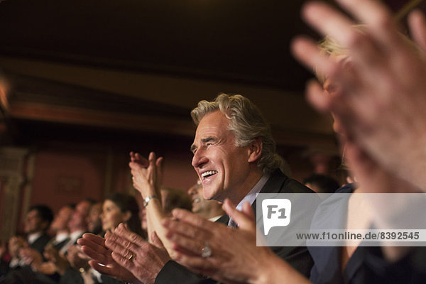 Enthusiastic man clapping in theater audience