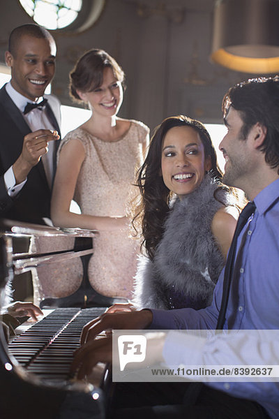 Gut gekleidete Freunde spielen Klavier in einem luxuriösen Nachtclub.