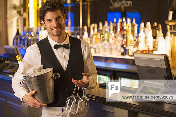 Porträt eines gut gekleideten Barkeepers mit Champagnerkübel in der Luxusbar
