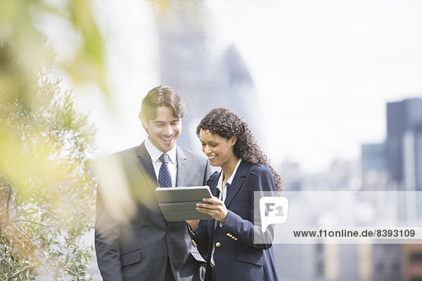 Business people using digital tablet outdoors