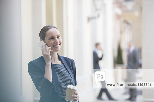 Geschäftsfrau im Gespräch auf dem Handy auf der Stadtstraße