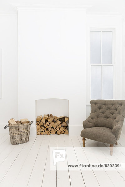 Brennholz und Sessel im Wohnzimmer