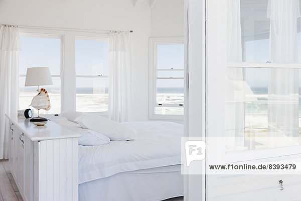 Weißes Schlafzimmer mit Blick auf den Ozean