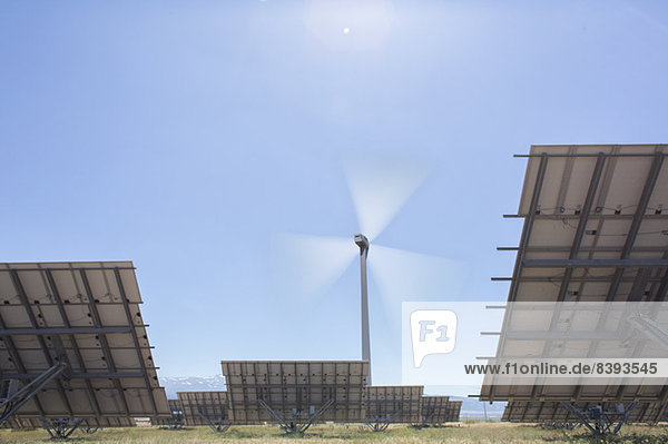 Windkraftanlage und Sonnenkollektoren in ländlicher Landschaft