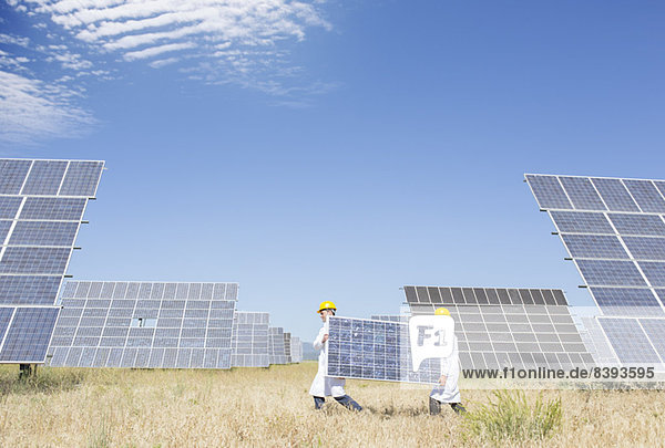 Wissenschaftler mit Solarmodul in ländlicher Landschaft
