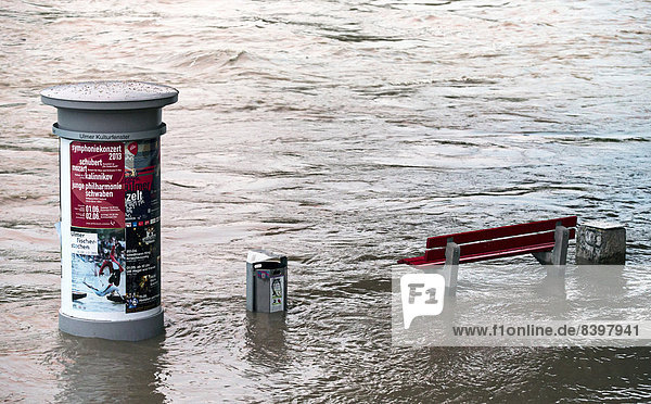 Advertising column and a bench in the flood waters of the Danube River  near Ulm  Baden-Württemberg  Germany