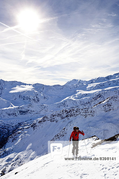 Cross-country skier ascending Kalfanwand Mountain in the Martell Valley  in front of the mountains of Veneziaspitzen and Zufallspitze  Alto Adige  Italy