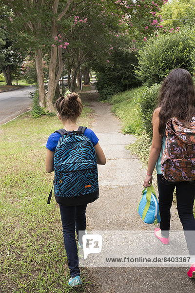Mixed race girls walking to school