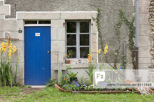 Blaue Haustür und Holzfenster eines alten Bauernhauses im Sommer Anzême Département Creuse Limousin Frankreich
