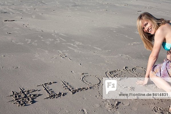Junge Frau schreibt Liebesbotschaft in Sand  Breezy Point  Queens  New York  USA