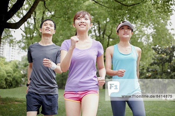 Drei junge Leute joggen im Park