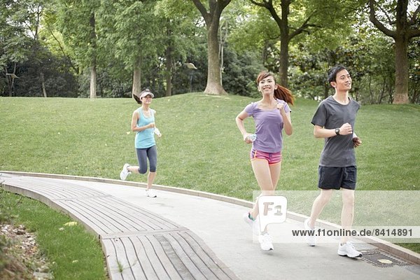 Three runners on path in park