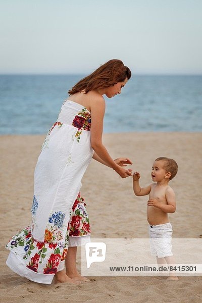 Mutter und Kleinkind am Strand stehend