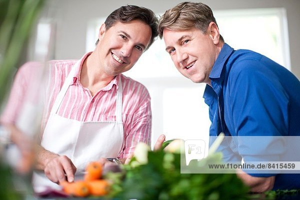 Reife Männer kochen  bereiten frisches Gemüse zu