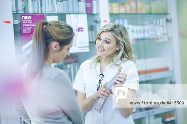 Pharmacist showing customer box of medication