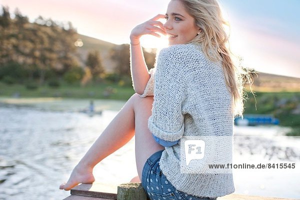 Young woman sitting on pier