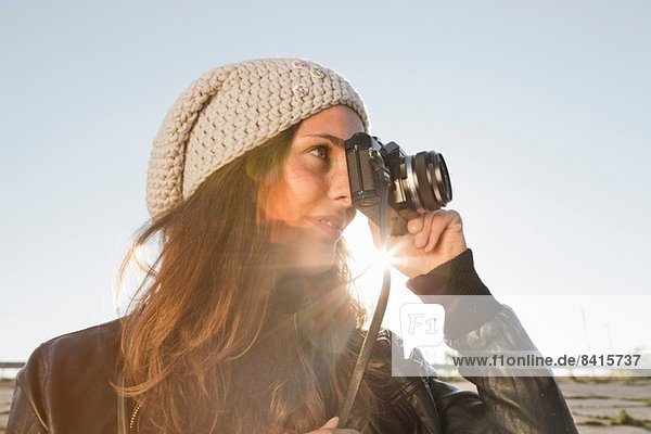 Portrait of young woman using slr camera