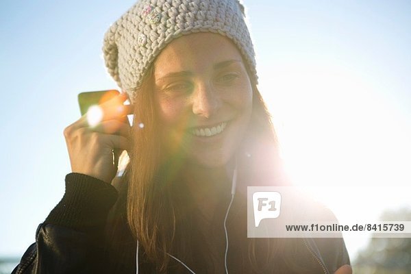 Portrait of young woman wearing earphones listening to music