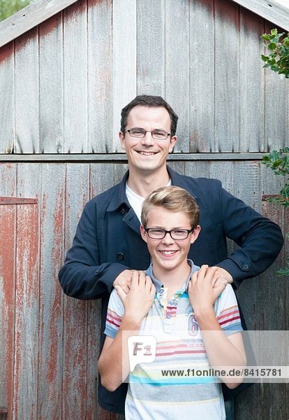 Portrait of father and teenage son in garden
