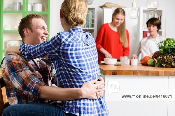 Junges Paar in der Küche mit Frau und Teenagermädchen