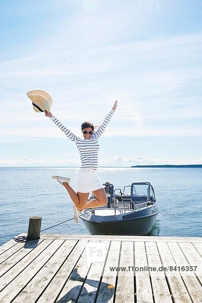Junge Frau springt in der Luft auf dem Pier  Gavle  Schweden