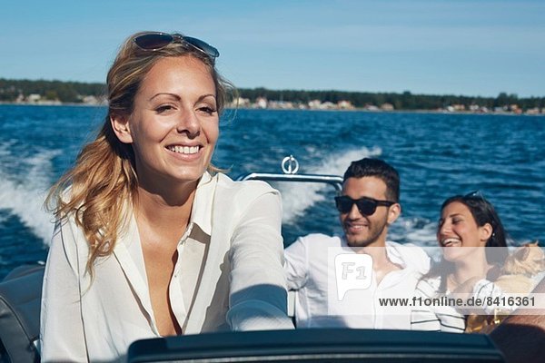 Junge Frau steuert Boot mit Freunden im Hintergrund  Gavle  Schweden