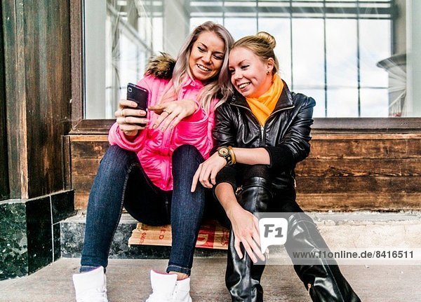 Two female friends looking at mobile phone