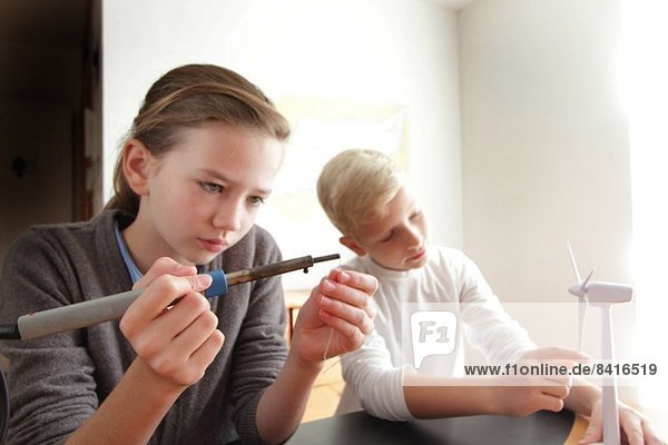 Mädchen und Junge machen ein Modell einer Windkraftanlage