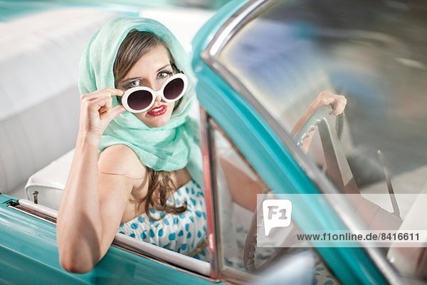 Frau im Kopftuch senkende Sonnenbrille im Vintage Cabriolet