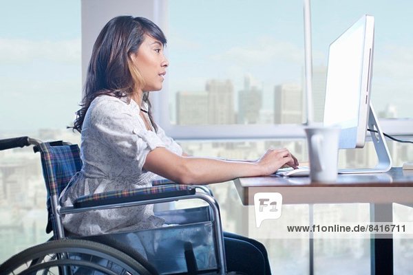 Frau im Rollstuhl mit Computer