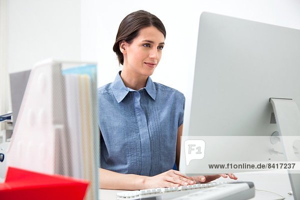 Junge Frau  die am Computer arbeitet