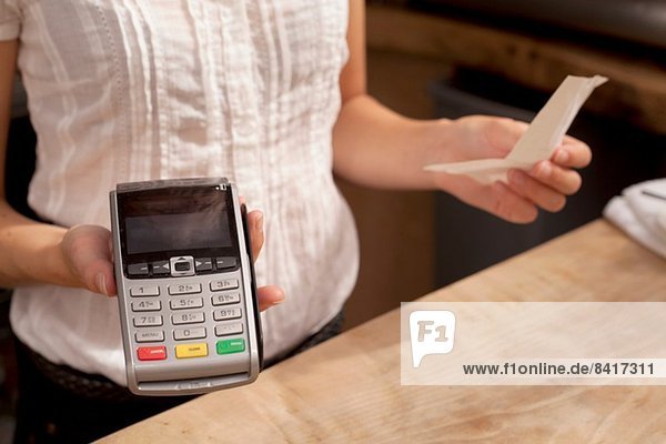 Nahaufnahme der Kellnerin mit Kreditkartenleser an der Küchenzeile