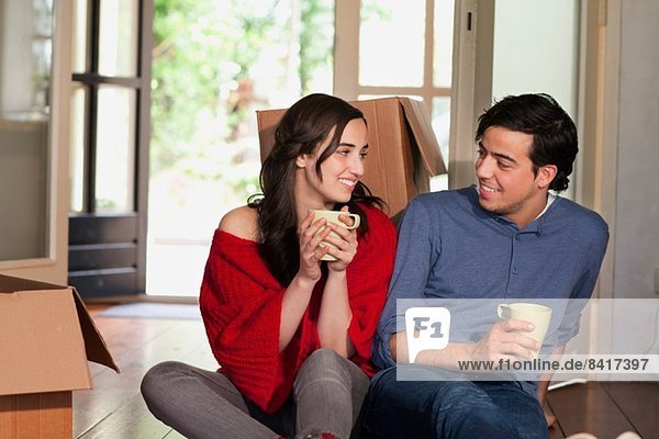 Young couple having coffee break whilst moving house