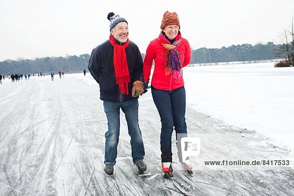 Couple ice skating  holding hands