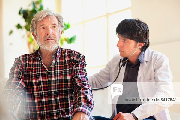 Doctor examining senior man