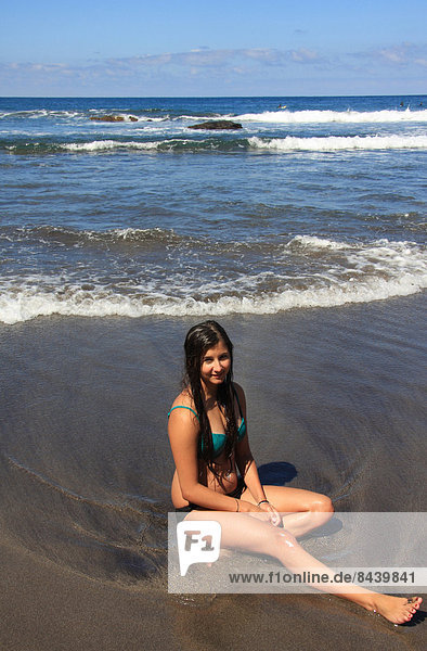 sitzend  Wasser  Jugendlicher  Europa  Frau  Strand  Bikini  Küste  braunhaarig  Kanaren  Kanarische Inseln  Mädchen  Spanien  Teneriffa