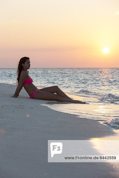 Maledives  young woman sitting at beach