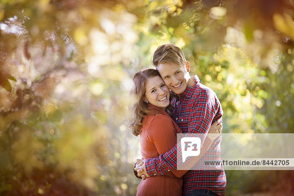 Happy young couple enjoying autumn in a park